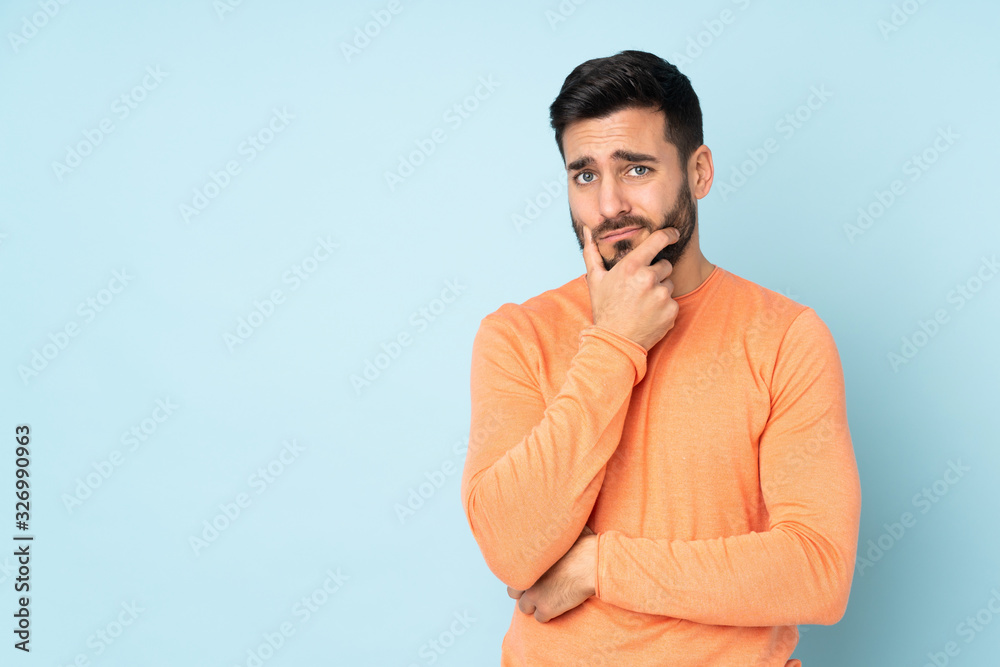 Caucasian handsome man having doubts over isolated blue background Caucasian handsome man having doubts over isolated blue background