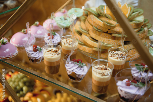 Delicious sweets on wedding candy buffet with desserts, cupcakes,tiramisu and cookies