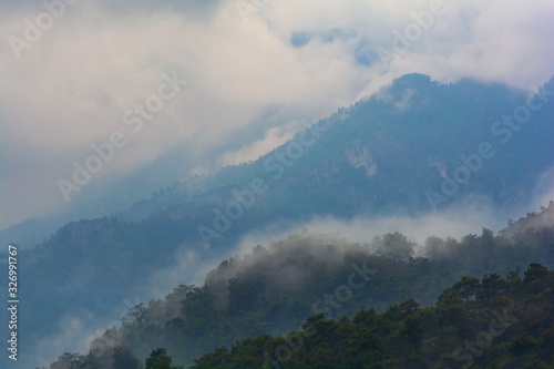 Mountains after rain. Water evaporating off the forest. Forest covered by low clouds.