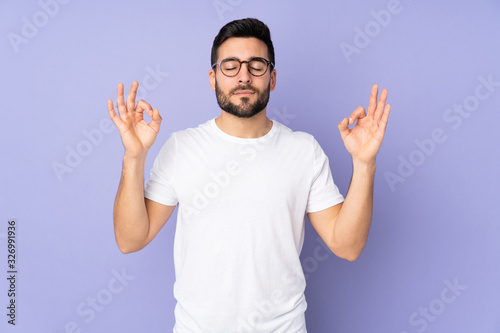 Caucasian handsome man over isolated background in zen pose