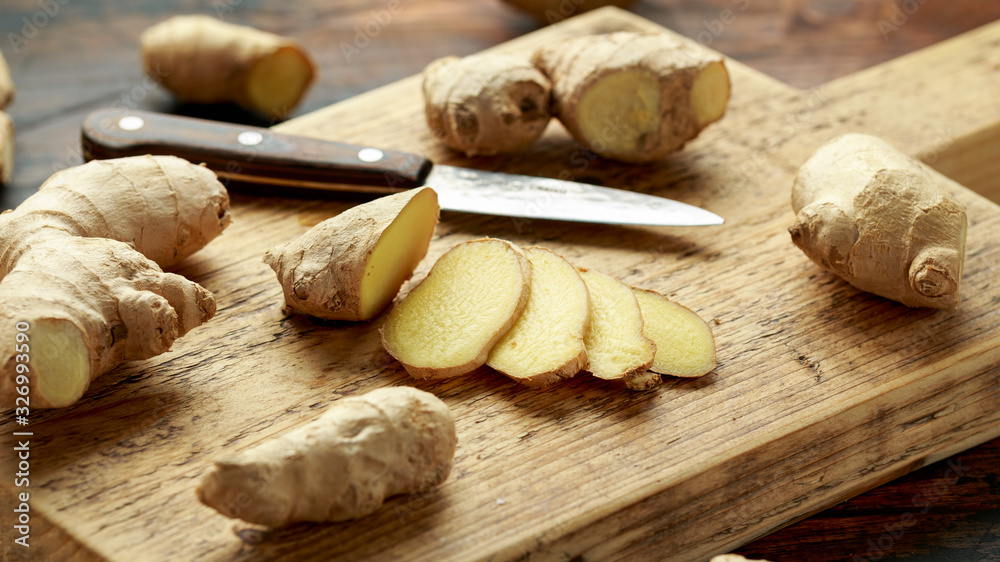 Fototapeta premium Fresh slice of Ginger on wooden chopping board. healthy food