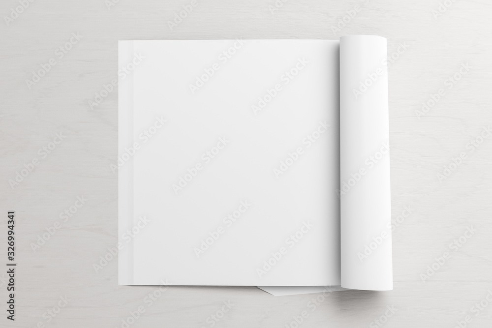 Blank square left magazine page. Workspace with folded magazine mock up on white desk. View above. 3d illustration