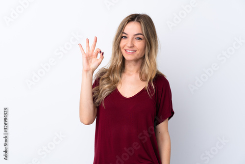 Young woman over isolated white background showing ok sign with fingers