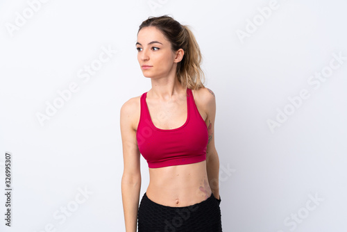 Young sport woman over isolated white background stretching leg © luismolinero
