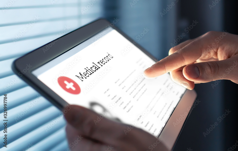 Medical record in electronic form. Digital EMR with patient health care  information. Doctor using tablet in hospital or clinic. Personal data in  mobile device. Online database for healthcare history. Stock Photo