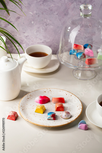 Tea in cup and chocolate candy, coffee in white cup