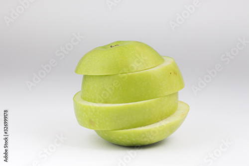 Closed up isolate sliced green apple tower . Ripped healthy green fruit on white background.