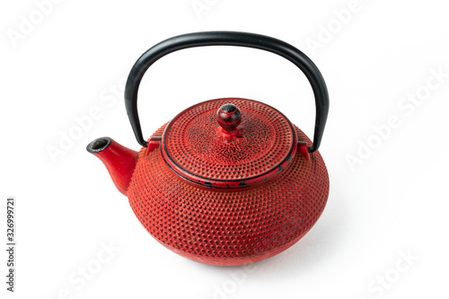Red cast iron teapot on a white background. Asian culture.
