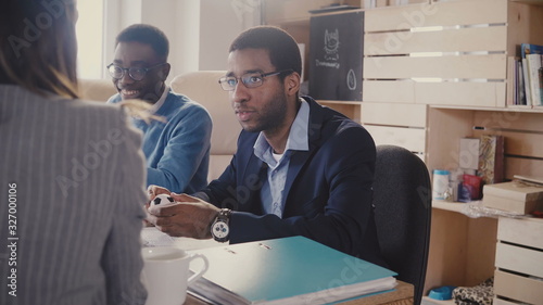 Happy African American executive laughs at multiethnic meeting in office, then goes serious again talking to lawyer 4K.