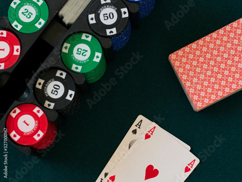 poker chips and ace of spades and ace of hearts on a green cloth casino table gamble photo