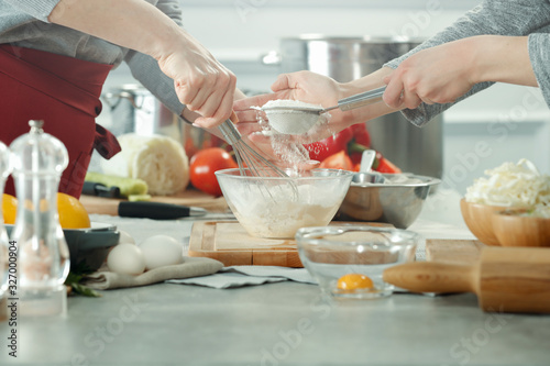 hands in the kitchen making dough on a wooden table. Free space for an advertising product