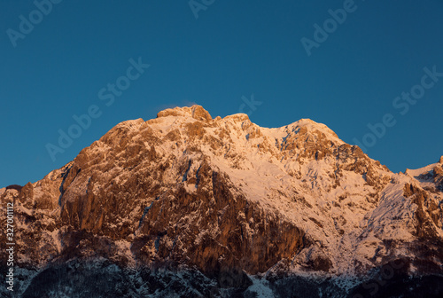 Mountain peak covered with snow at sunset