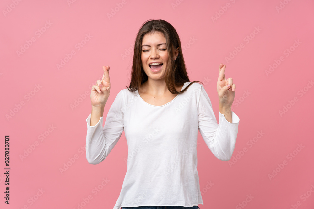 Young woman over isolated pink background with fingers crossing Young woman over isolated pink background with fingers crossing
