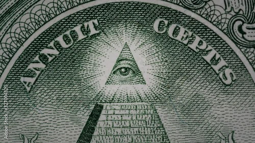 Creative 4k video of details of a 1 american dollar banknote macro closeup with a pyramid and the effect of a glowing mason eye on top. Pyramid close-up on a banknote of 1 US dollars.