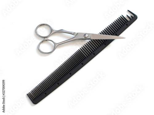 hairdresser professional scissors and black hairbrush comb isolated on white background close up