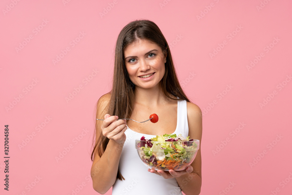Young woman with salad over isolated pink wall Young woman with salad over isolated pink wall