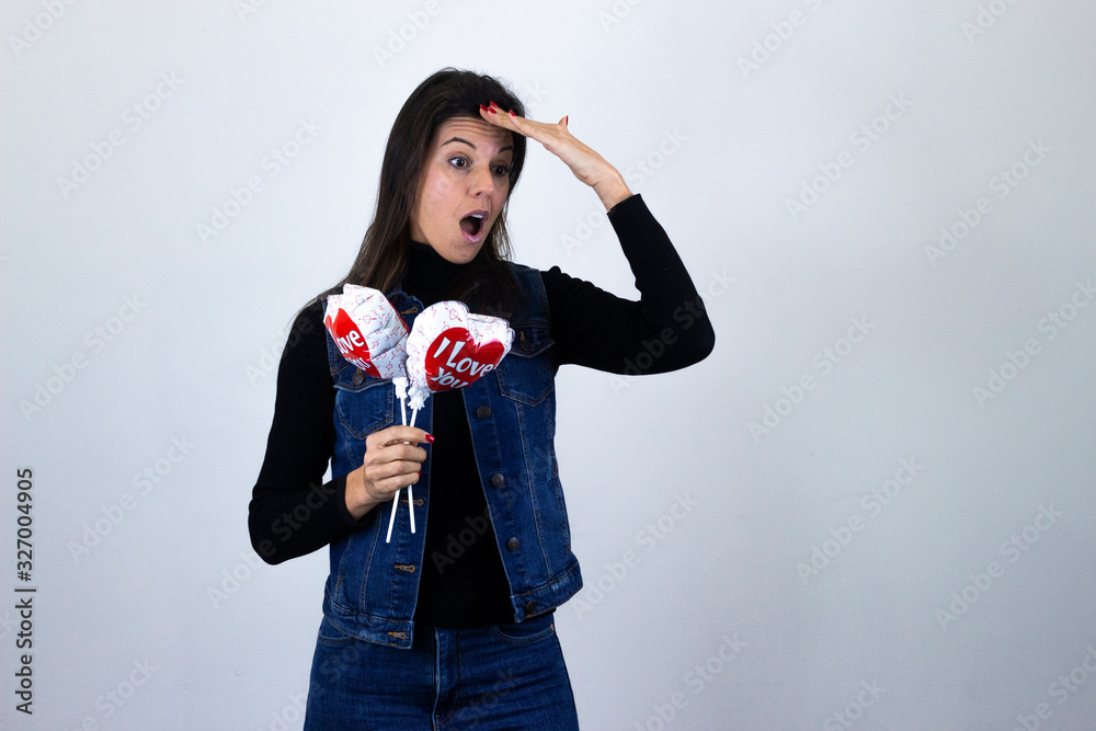 Fototapeta premium Simbolo de victoriapretty caucasian middle age woman with balloon i love you making victory or peace sign, isolated on gray background studio shotblack sweater, denim jacket, jeans, dark air. Place fo