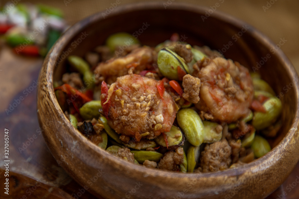 Stir Fried Bitter beans (Sator) with Shrimp in wooden bowl, It is a traditional food of southern Thailand. Stir Fried Bitter beans (Sator) with Shrimp in wooden bowl, It is a traditional food of southern Thailand.