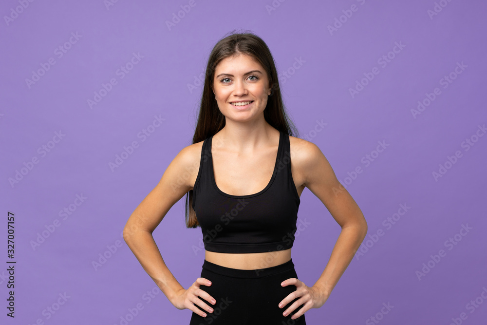 Young girl woman over isolated background posing with arms at hip and smiling Young girl woman over isolated background posing with arms at hip and smiling