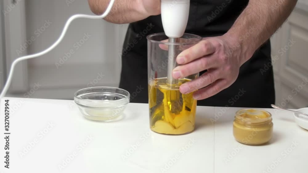 Man hands Cooking Homemade Mayonnaise with stick blender on white table Man hands Cooking Homemade Mayonnaise with stick blender on white table