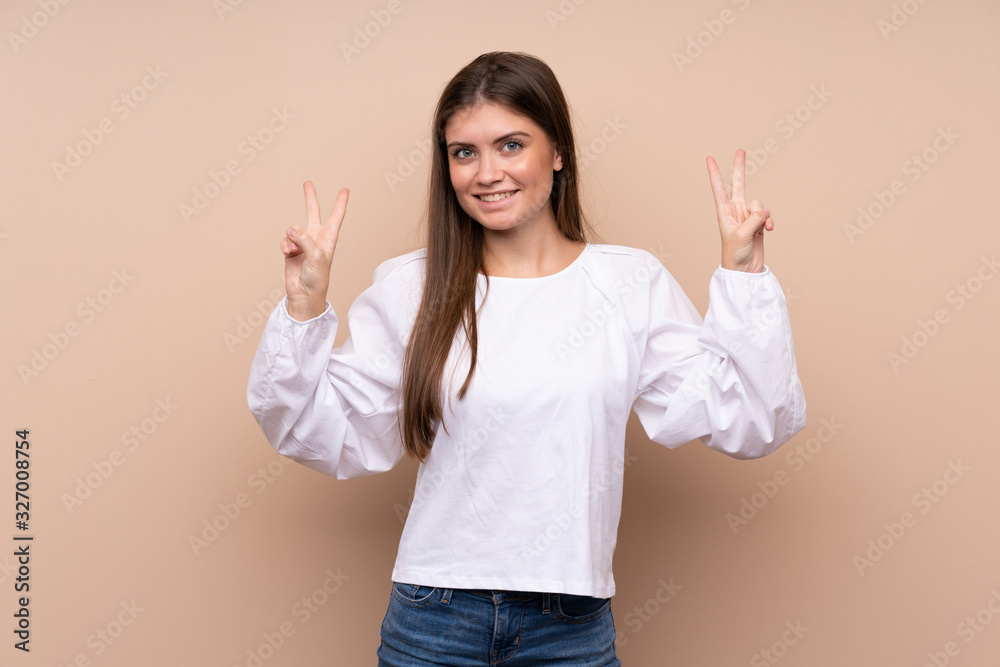 Young girl over isolated background showing victory sign with both hands Young girl over isolated background showing victory sign with both hands