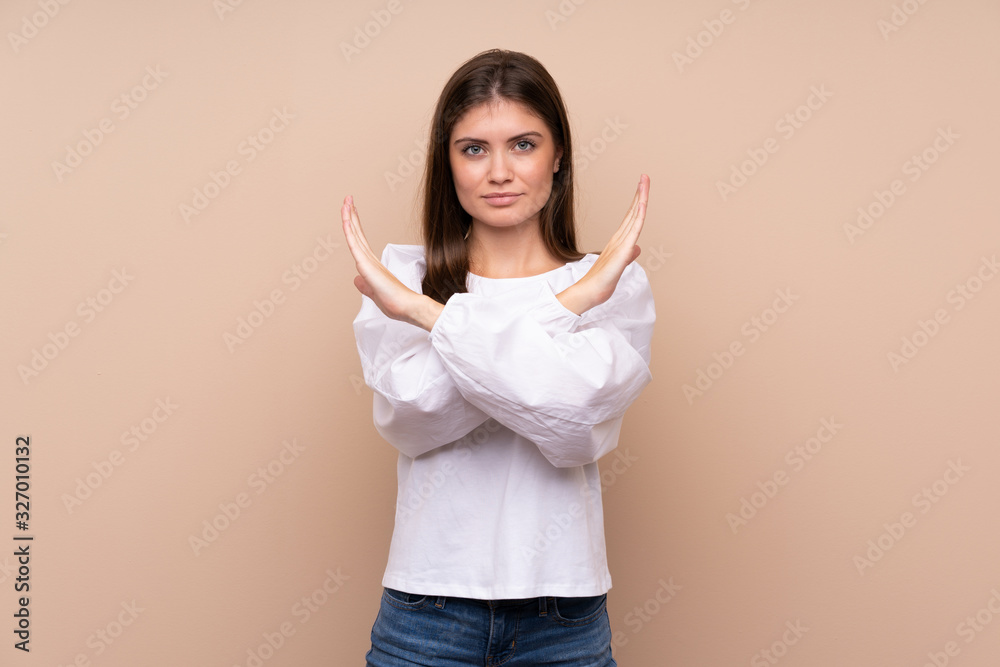 Young girl over isolated background making NO gesture