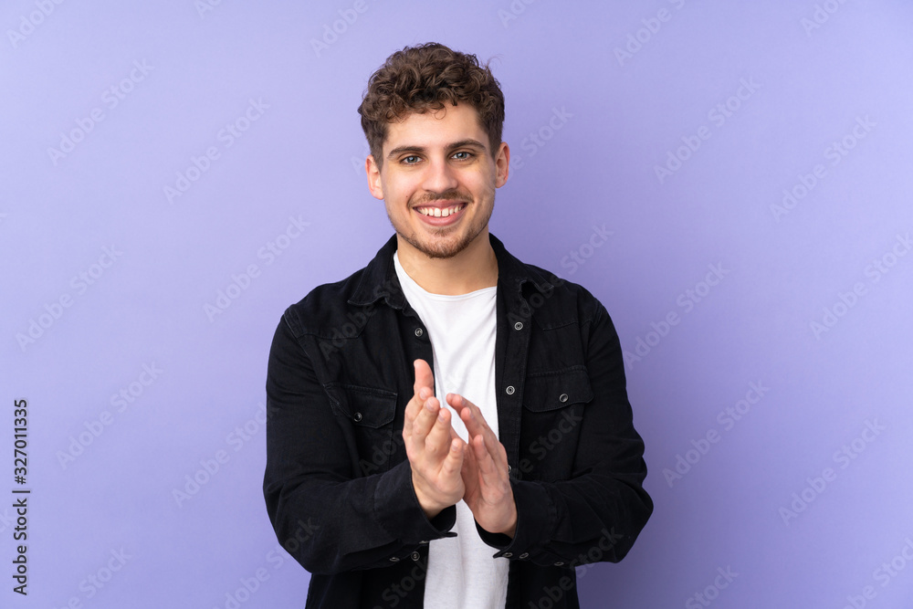 Caucasian man isolated on purple background applauding after presentation in a conference Caucasian man isolated on purple background applauding after presentation in a conference