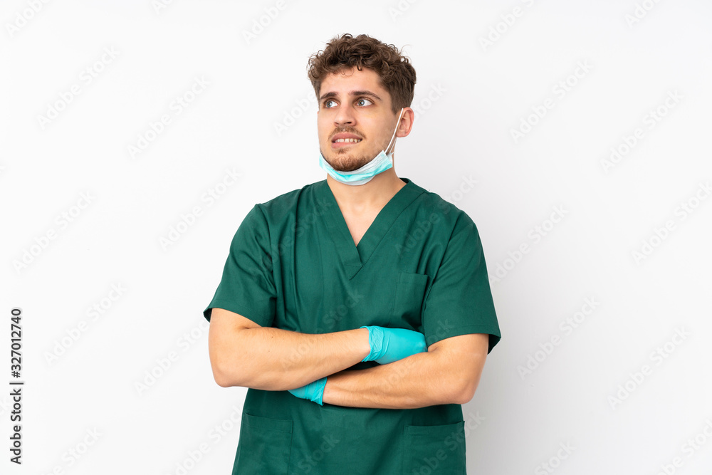 Surgeon in green uniform isolated on isolated white background with confuse face expression Surgeon in green uniform isolated on isolated white background with confuse face expression