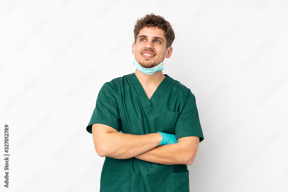 Surgeon in green uniform isolated on isolated white background looking up while smiling