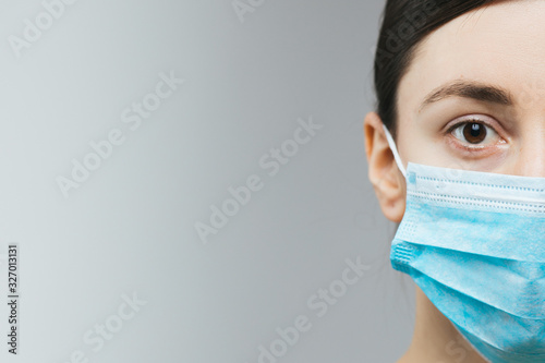 Woman with brown hair and a medical mask for protection again influenza. Copy space for your text. Woman with arms outstretched forward