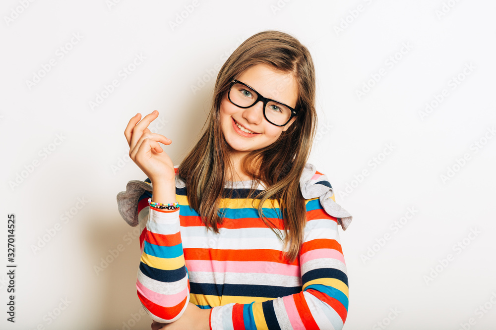 Studio portrait of beautiful young girl, wearing eyeglasses and colorful stripe long sleeve shirt Studio portrait of beautiful young girl, wearing eyeglasses and colorful stripe long sleeve shirt