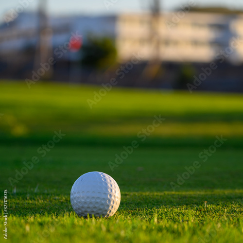 Excellent well-kept green grass lawn on large golf course, green section with big white foam ball for beginners on Tenerife island, Canary, Spain