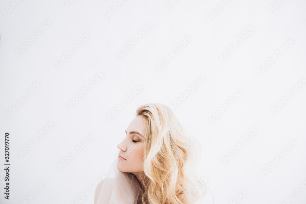 Stylish portrait of a blonde girl through the fabric. View from above. Stylish portrait of a blonde girl through the fabric. View from above.