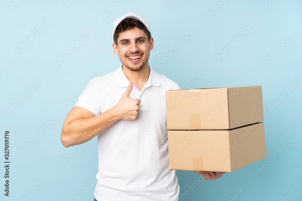 Delivery caucasian man isolated on blue background giving a thumbs up gesture Delivery caucasian man isolated on blue background giving a thumbs up gesture