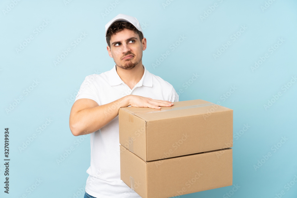 Delivery caucasian man isolated on blue background thinking an idea Delivery caucasian man isolated on blue background thinking an idea