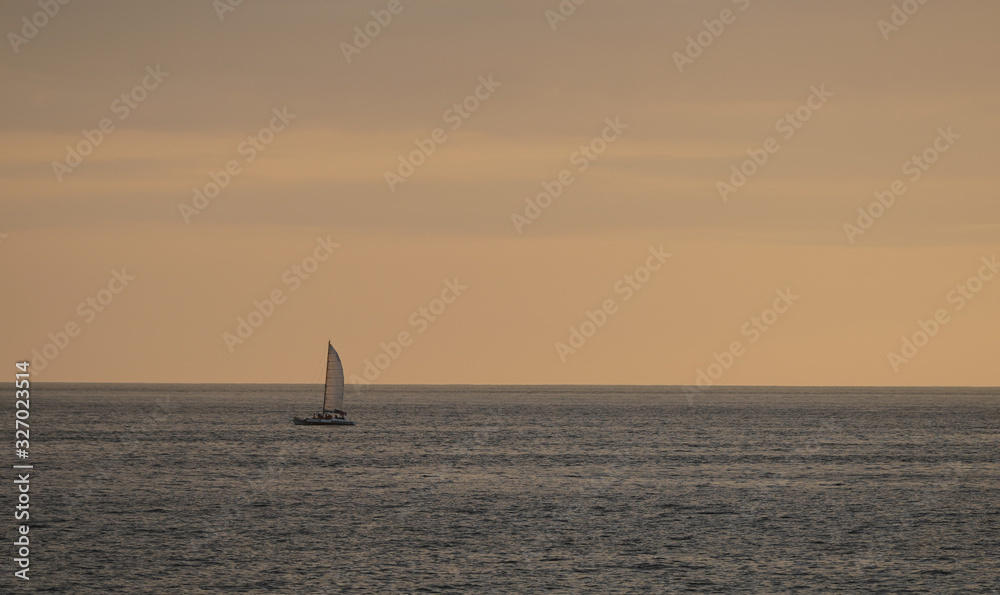 Beautiful sailboat sailing at sunset in Costa Rica Beach