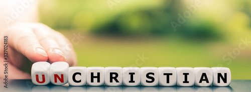 Cuadro en lienzo Hand turns dice and changes the  word  unchristian to christian