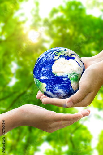 Fototapeta Naklejka Na Ścianę i Meble -  Woman hands holding world or globe give to another hand on earth day.Environment conservation and energy saving concept.Elements of this image are furnished by NASA.