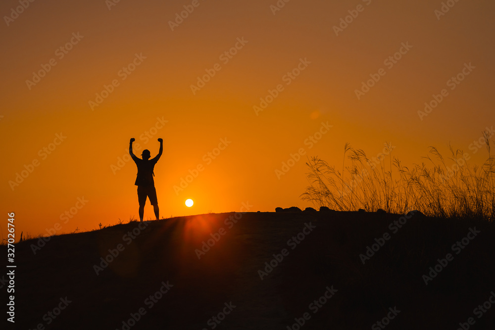 adventure travel from silhouette man hiking and stand on top of the mountain in summer season