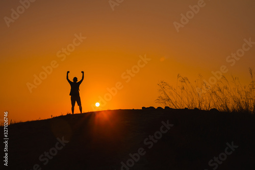 adventure travel from silhouette man hiking and stand on top of the mountain in summer season