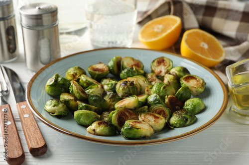 Composition with plate of brussels sprout on wooden background, close up