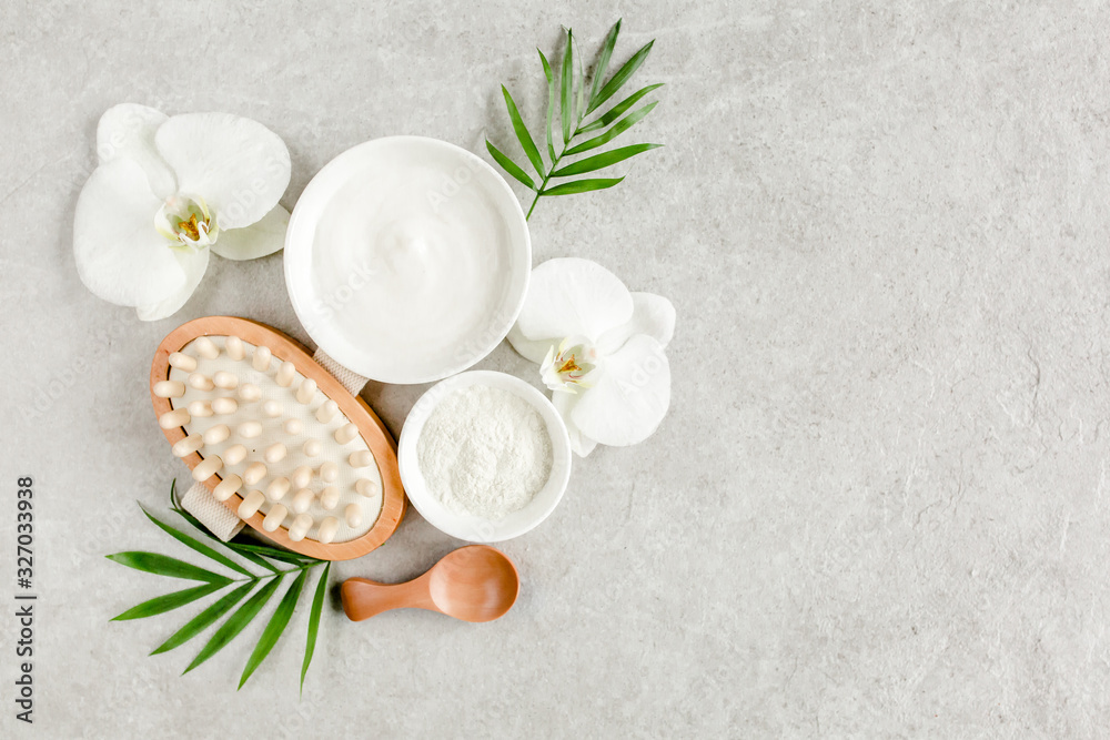 Spa treatment concept. Natural/Organic spa cosmetics products, sea salt, massage brush, tropic palm leaves on gray marble table from above. Spa background with a space for a text, flat lay, top view Spa treatment concept. Natural/Organic spa cosmetics products, sea salt, massage brush, tropic palm leaves on gray marble table from above. Spa background with a space for a text, flat lay, top view