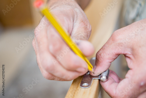 Closeup of carpenter with pencil working on door