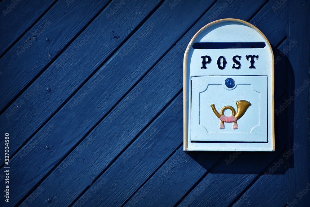 Old postbox on blue wooden door