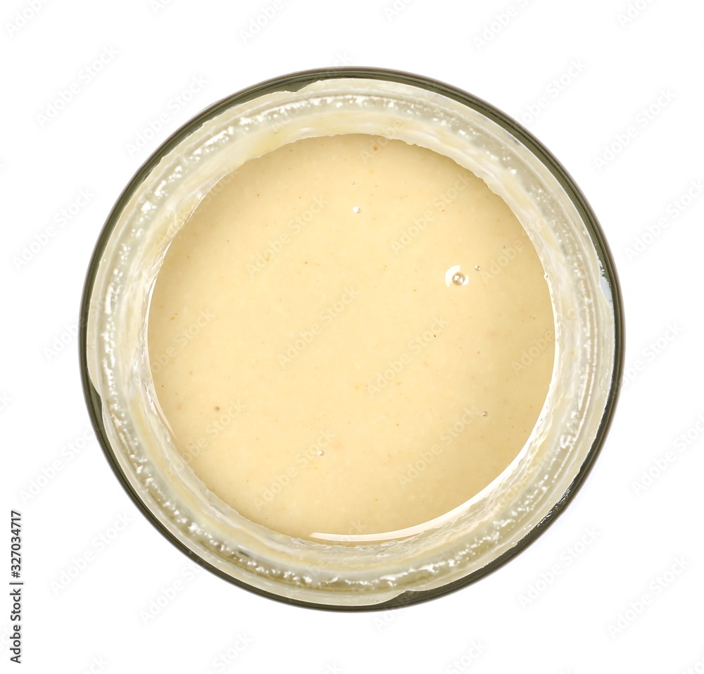 Sesame butter, paste tahini in glass jar isolated on white background, top view Sesame butter, paste tahini in glass jar isolated on white background, top view