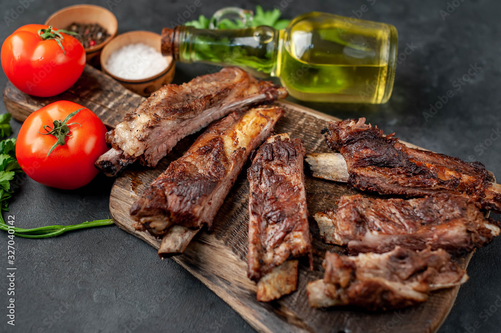 pork ribs with spices, tomatoes and herbs on a stone background pork ribs with spices, tomatoes and herbs on a stone background