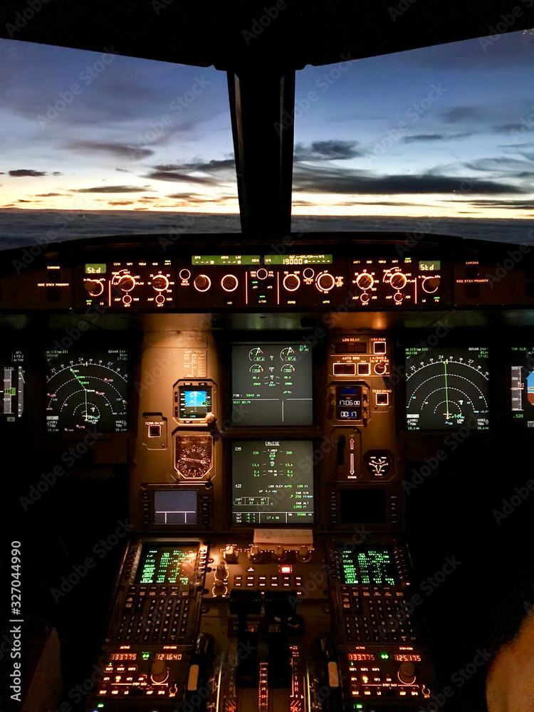 Cockpit view from the cosy jump seat of an Airbus A320 at sunset Stock