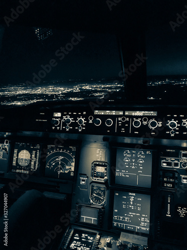 Stunning edited image of the atmosphere inside the cockpit of an Airbus A320 during an approach over a city at night