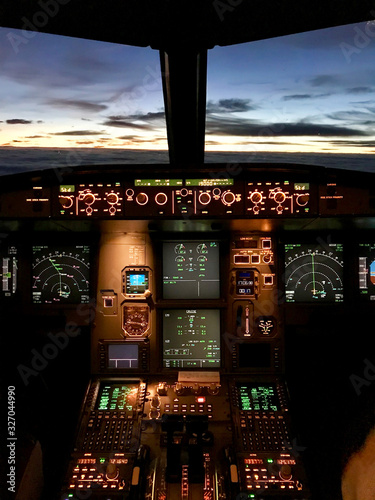Cockpit view from the cosy jump seat of an Airbus A320 at sunset