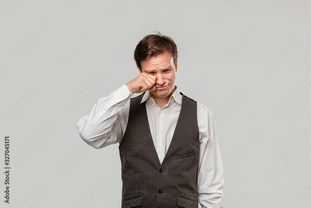 Handsome man in a white shirt and grey vest crying because he faces some problems need to be addressed Handsome man in a white shirt and grey vest crying because he faces some problems need to be addressed
